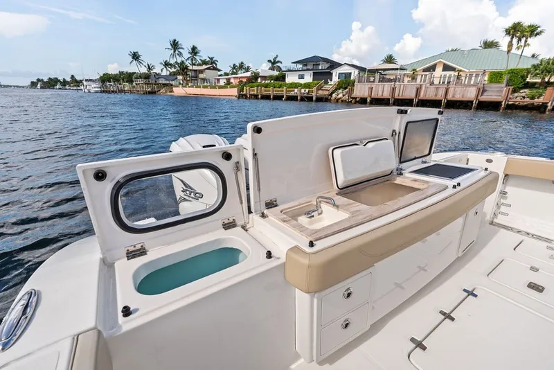 Slide: The Image of 2020 Pursuit S 408 Sport boat with open deck, sink, and storage compartments. - 20