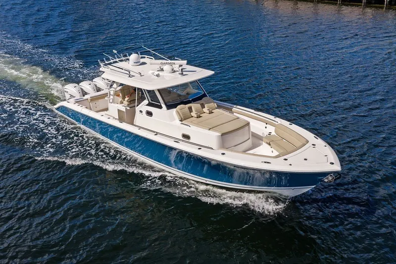 Slide: The Image of 2020 Pursuit S 408 Sport boat cruising on open water, showcasing sleek design and powerful engines. - 4