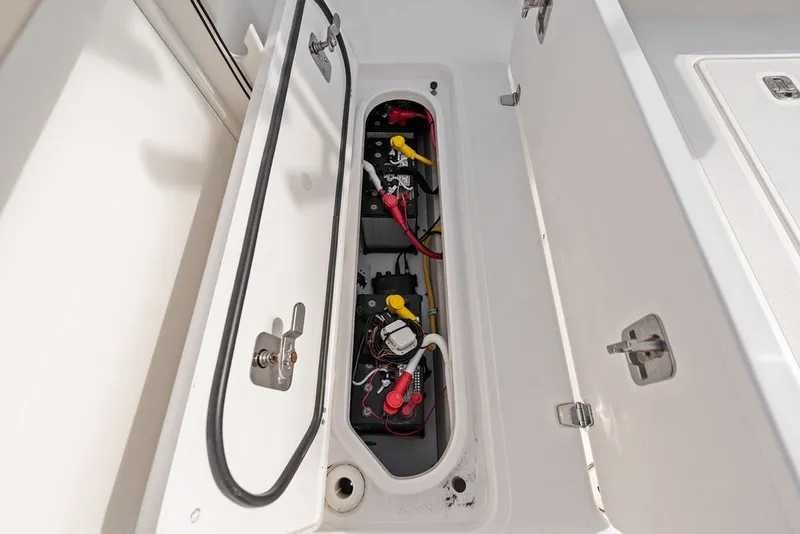 Slide: The Image of 2020 Pursuit S 408 Sport boat battery compartment with wiring and secure latches. - 24