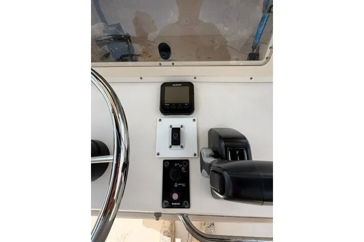Slide: The Image of Control panel of a 2006 Parker 2100 Special Edition boat with steering wheel and throttle. - 23