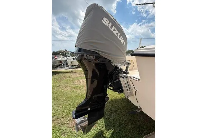 Slide: The Image of Suzuki outboard motor on 2006 Parker 2100 Special Edition boat, covered and parked on grass. - 6