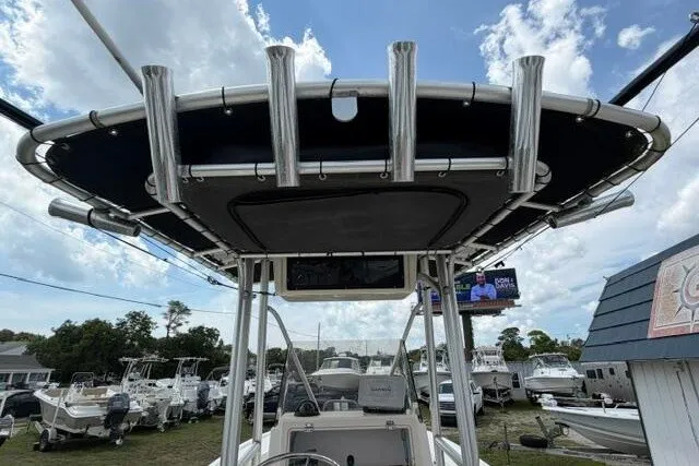 Slide: The Image of 2006 Parker 2100 Special Edition boat with T-top and rod holders, docked under a cloudy sky. - 27
