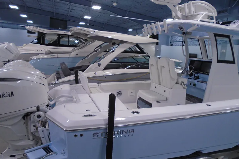 Slide: The Image of 2027 Striking Boats 27XB model displayed in a showroom with other luxury boats. - 36