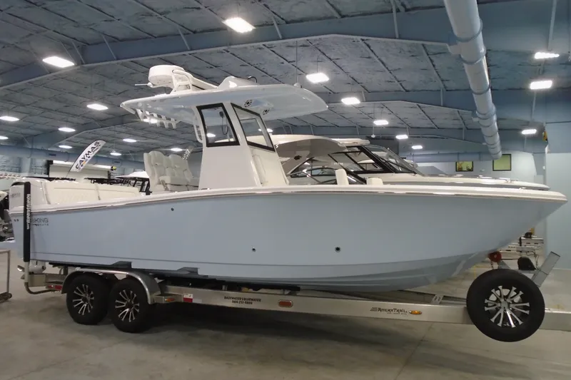 The Image of 2027 Striking Boats 27XB on trailer in indoor showroom, showcasing sleek design and modern features. - 0