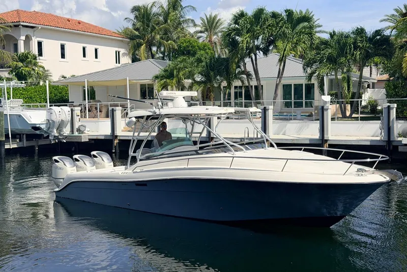 Slide: The Image of 2005 Hydra-Sports Vector 3300 VX boat docked near waterfront homes with palm trees. - 1
