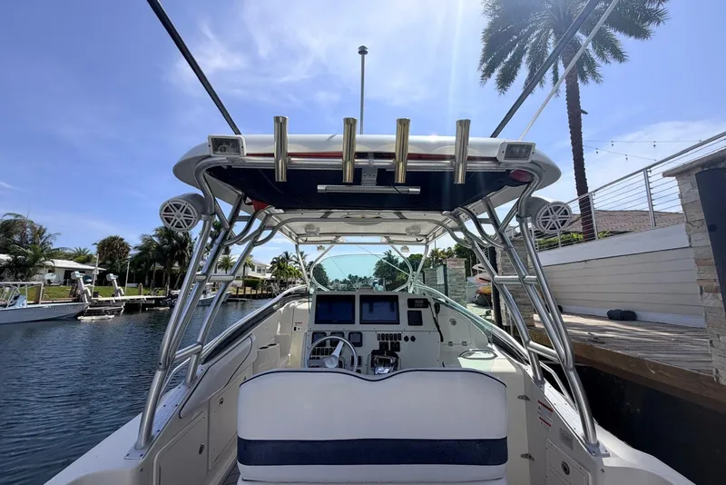 Slide: The Image of 2005 Hydra-Sports Vector 3300 VX boat interior with helm, docked by palm trees. - 23