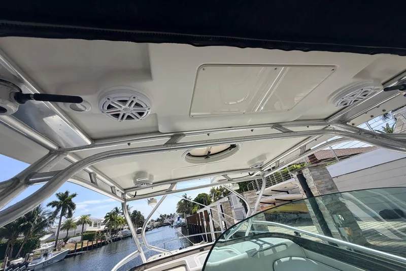 Slide: The Image of 2005 Hydra-Sports Vector 3300 VX boat interior with speakers and canopy, docked by palm trees. - 22