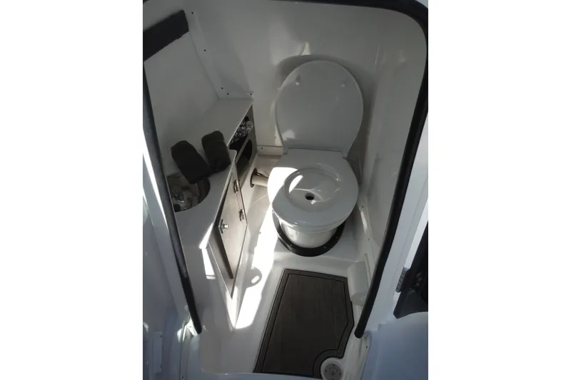 Slide: The Image of 2024 Monterey 255SS Super Sport boat interior bathroom with toilet and storage cabinet. - 31