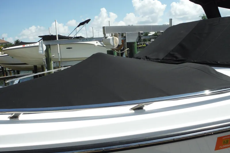 Slide: The Image of 2024 Monterey 255SS Super Sport boat with black cover docked under clear skies. - 41