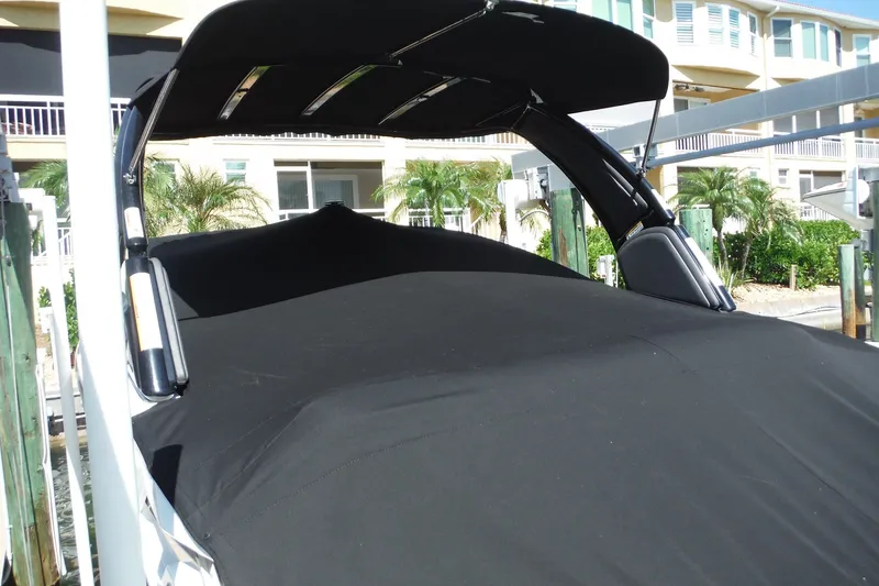 Slide: The Image of 2024 Monterey 255SS Super Sport boat with black cover docked near waterfront homes. - 40