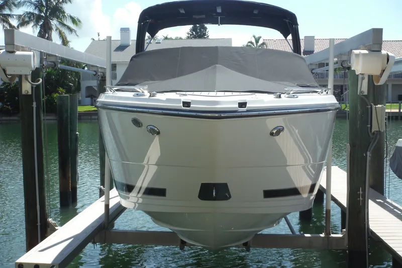 Slide: The Image of 2024 Monterey 255SS Super Sport boat docked on a lift by the water. - 42