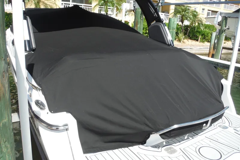 Slide: The Image of 2024 Monterey 255SS Super Sport boat covered with a black tarp at a dock. - 39