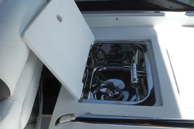 Slide: The Image of 2024 Monterey 255SS Super Sport boat sink with chrome faucet and cutting board. - 15