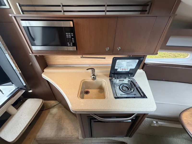 Slide: The Image of The galley of a 2014 Sea Ray Sundancer 280 with a microwave, sink, and stove. - 32