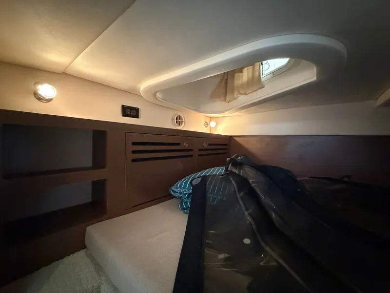 Slide: The Image of Interior of a 2014 Sea Ray Sundancer 280 with a cozy bed and lighting. - 37