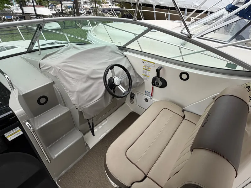 Slide: The Image of The image shows the cockpit of a 2014 Sea Ray Sundancer 280 with a covered helm. - 21