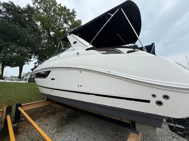 Slide: The Image of A 2014 Sea Ray Sundancer 280 on a trailer, featuring a black canopy and sleek white exterior. - 13