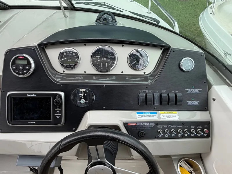 Slide: The Image of The dashboard of a 2014 Sea Ray Sundancer 280 with instruments and controls. - 23