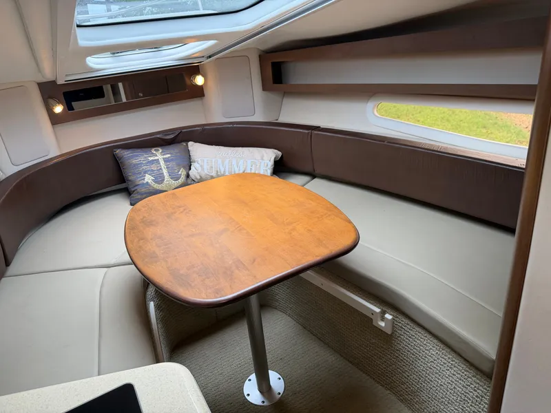 Slide: The Image of Interior of a 2014 Sea Ray Sundancer 280 featuring a sleek wooden table and comfortable seating. - 28