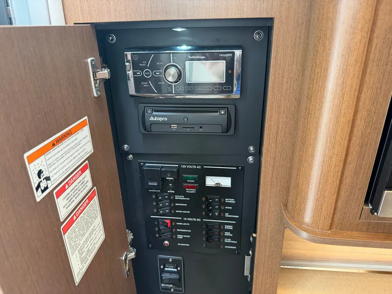 Slide: The Image of A control panel with an audio system and various switches inside a boat. - 38