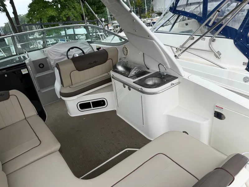 Slide: The Image of The image shows the cockpit of a 2014 Sea Ray Sundancer 280 with seating and a small kitchenette. - 16