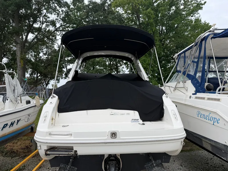 Slide: The Image of A 2014 Sea Ray Sundancer 280 is on land. It features a black canopy. - 14