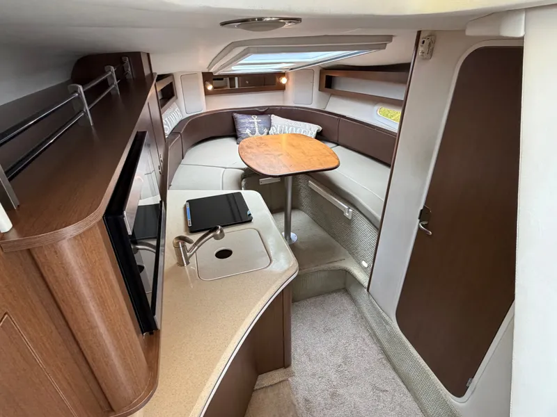Slide: The Image of Interior of a 2014 Sea Ray Sundancer 280 with a cozy seating area and table. - 26