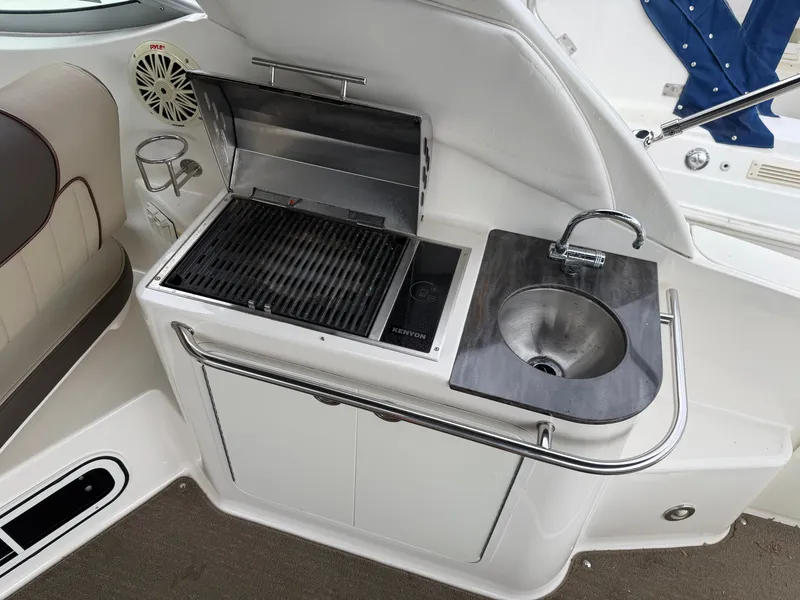 Slide: The Image of The 2014 Sea Ray Sundancer 280 features an outdoor kitchenette with a grill and sink. - 19