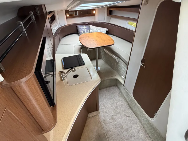 Slide: The Image of Interior of the 2014 Sea Ray Sundancer 280 with cozy seating area and table. - 25