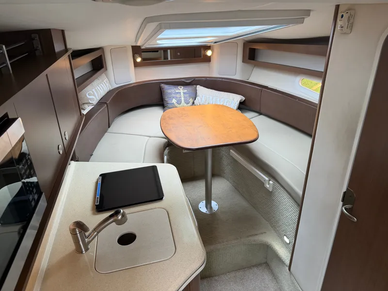 Slide: The Image of Interior of a 2014 Sea Ray Sundancer 280 with a cozy seating area and table. - 27