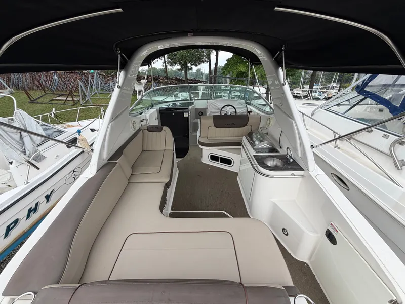 Slide: The Image of The image shows the cockpit of a 2014 Sea Ray Sundancer 280 with beige upholstery and a small kitchenette. - 15