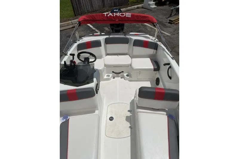 Slide: The Image of 2021 Tahoe T16 boat interior with red and gray seating, steering wheel, and canopy. - 9