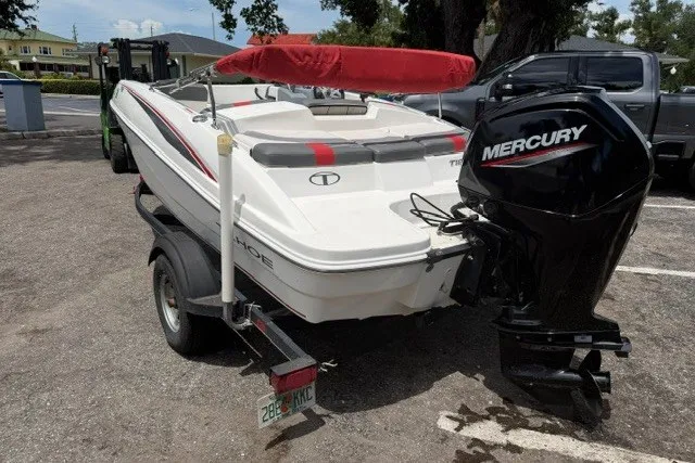 Slide: The Image of 2021 Tahoe T16 boat with Mercury engine, parked on a trailer in a lot. - 5