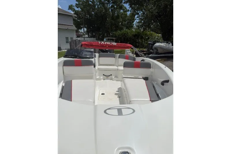 Slide: The Image of 2021 Tahoe T16 boat with red and gray seating, parked outdoors. - 7