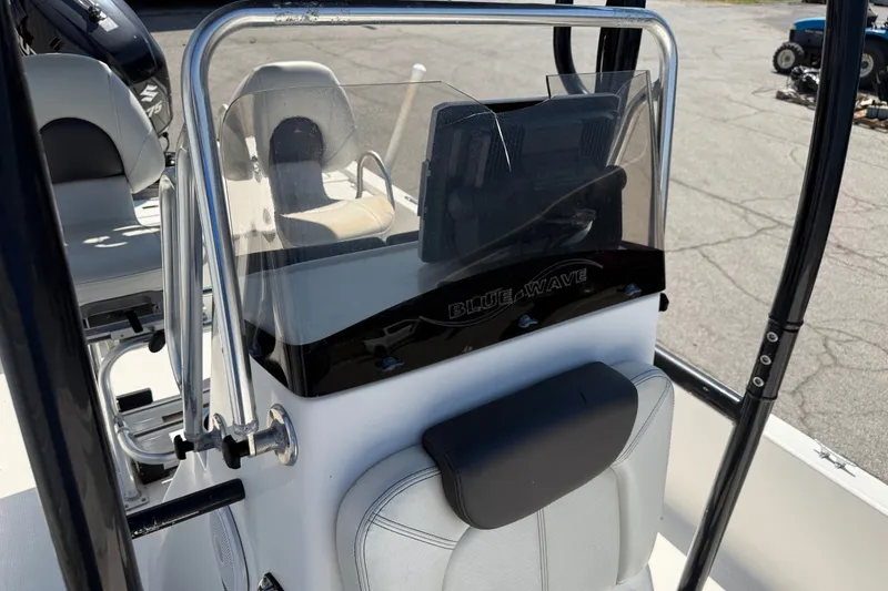 Slide: The Image of 2016 Blue Wave 2200 STL boat console with windshield and seating, showcasing sleek design. - 19