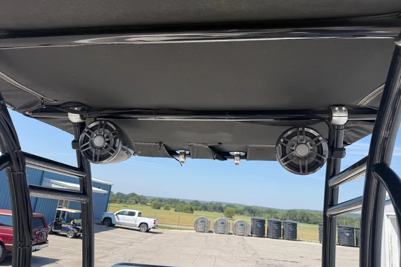 Slide: The Image of 2016 Blue Wave 2200 STL boat speakers and canopy, parked outdoors. - 26