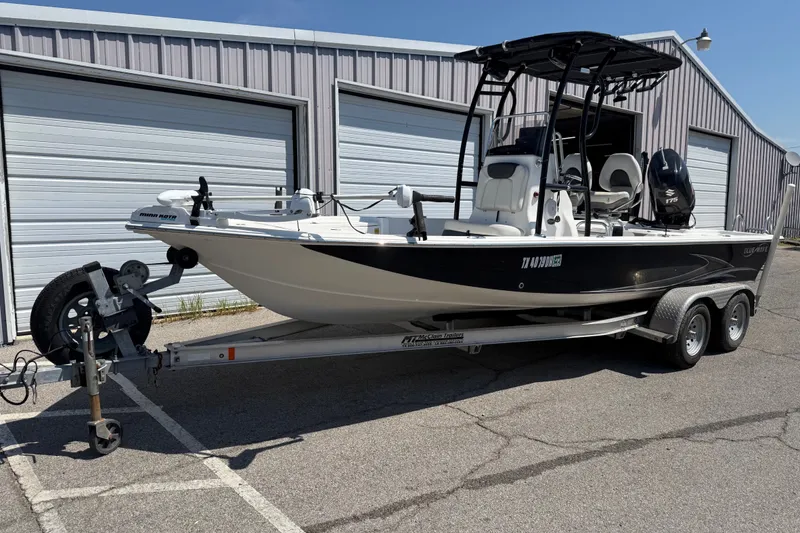 Slide: The Image of 2016 Blue Wave 2200 STL boat on trailer, parked outside storage units. - 1