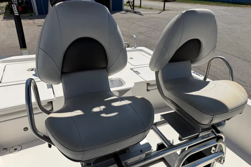 Slide: The Image of Two cushioned boat seats on a 2016 Blue Wave 2200 STL, featuring stainless steel armrests. - 20