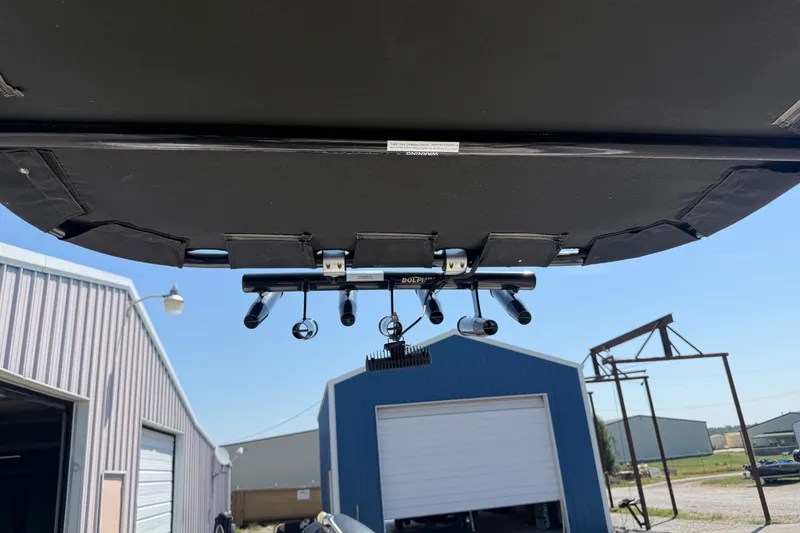 Slide: The Image of 2016 Blue Wave 2200 STL boat with mounted fishing rod holders, parked near storage buildings. - 27