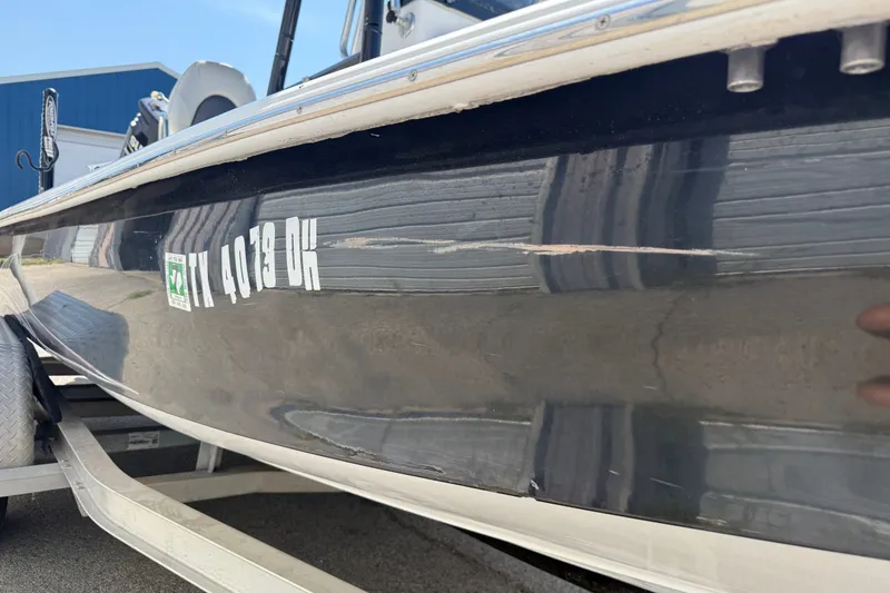 Slide: The Image of 2016 Blue Wave 2200 STL boat on trailer, showing side view with visible scratch. - 7