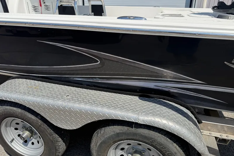 Slide: The Image of 2016 Blue Wave 2200 STL boat on a metal trailer, showcasing sleek black design. - 10