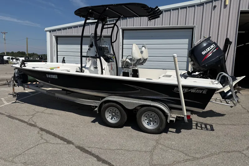 The Image of 2016 Blue Wave 2200 STL boat on trailer, parked outside a garage. - 0