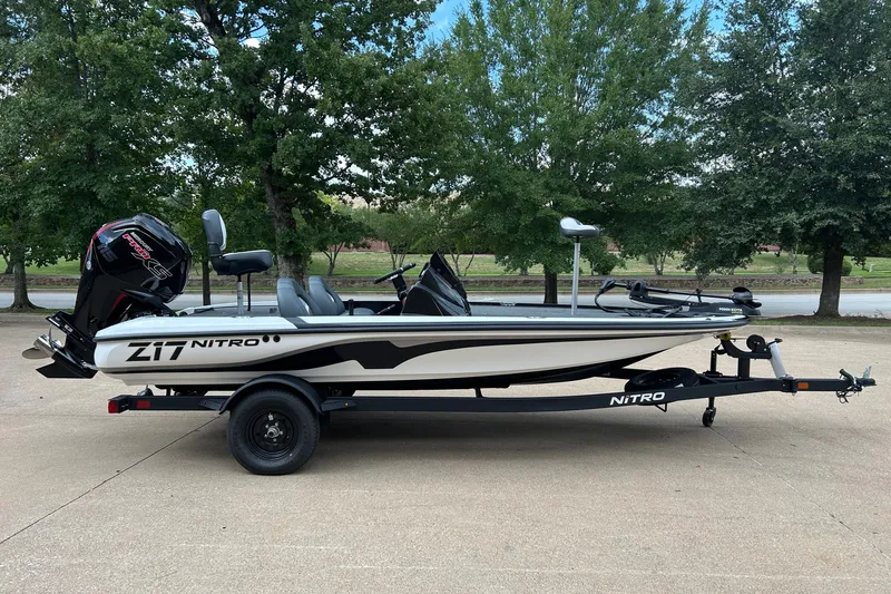 The Image of 2027 Nitro Z17 boat on trailer, parked outdoors with trees in background. - 0