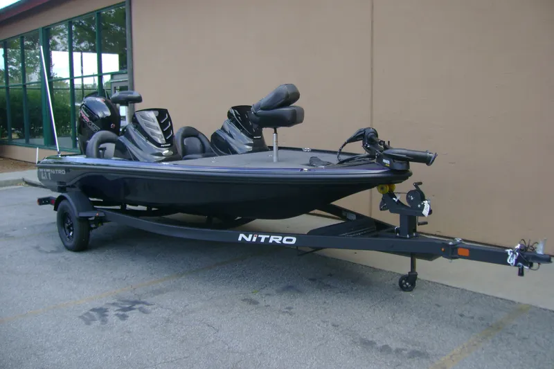 Slide: The Image of 2027 Nitro Z17 fishing boat on trailer, parked outdoors near a building. - 2