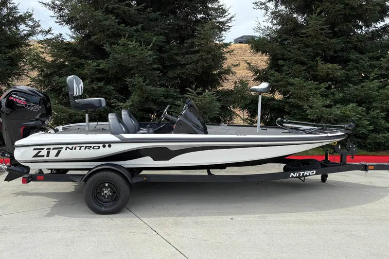 The Image of 2027 Nitro Z17 boat on trailer, parked outdoors near trees. - 0