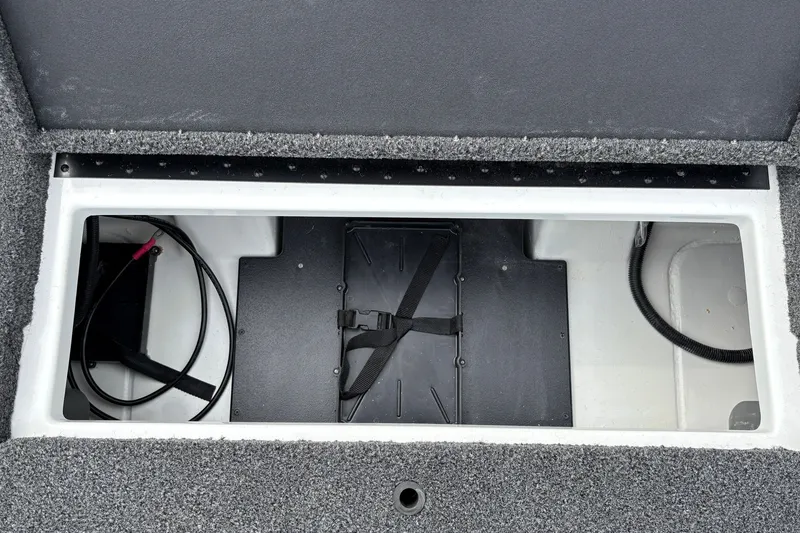 Slide: The Image of Open storage compartment in a 2027 Nitro Z17 boat, featuring cables and a secured battery. - 31