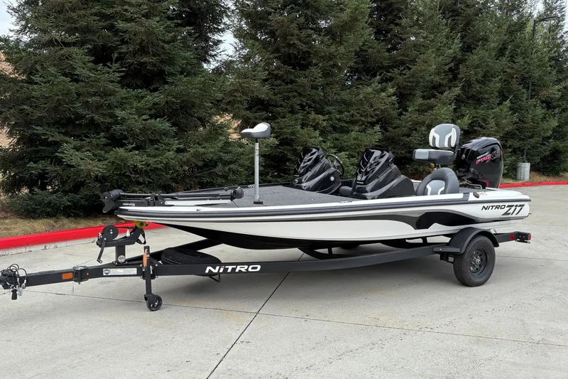 Slide: The Image of 2027 Nitro Z17 fishing boat on trailer, parked near trees. - 3