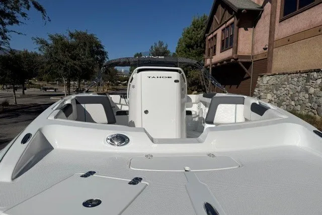 Slide: The Image of 2026 Tahoe 2150 CC boat with sleek design, docked near a rustic building. - 7
