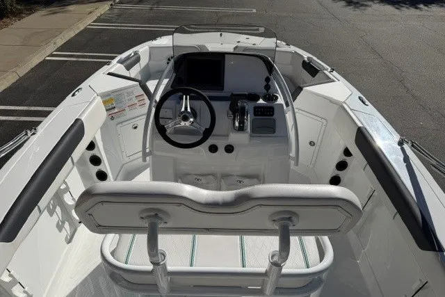 Slide: The Image of 2026 Tahoe 2150 CC boat cockpit with steering wheel, controls, and seating in a parking lot. - 9
