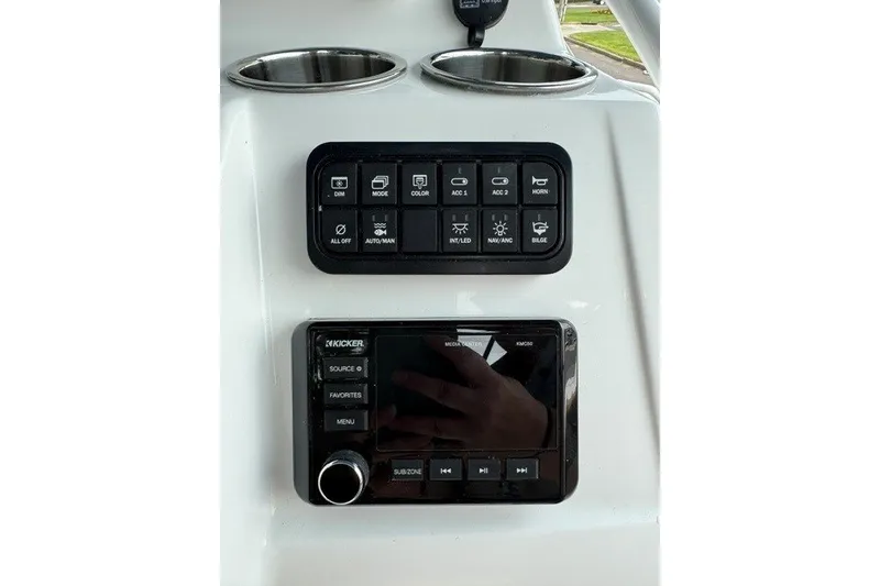 Slide: The Image of Control panel of 2026 Tahoe 2150 CC boat with audio system and switches. - 14